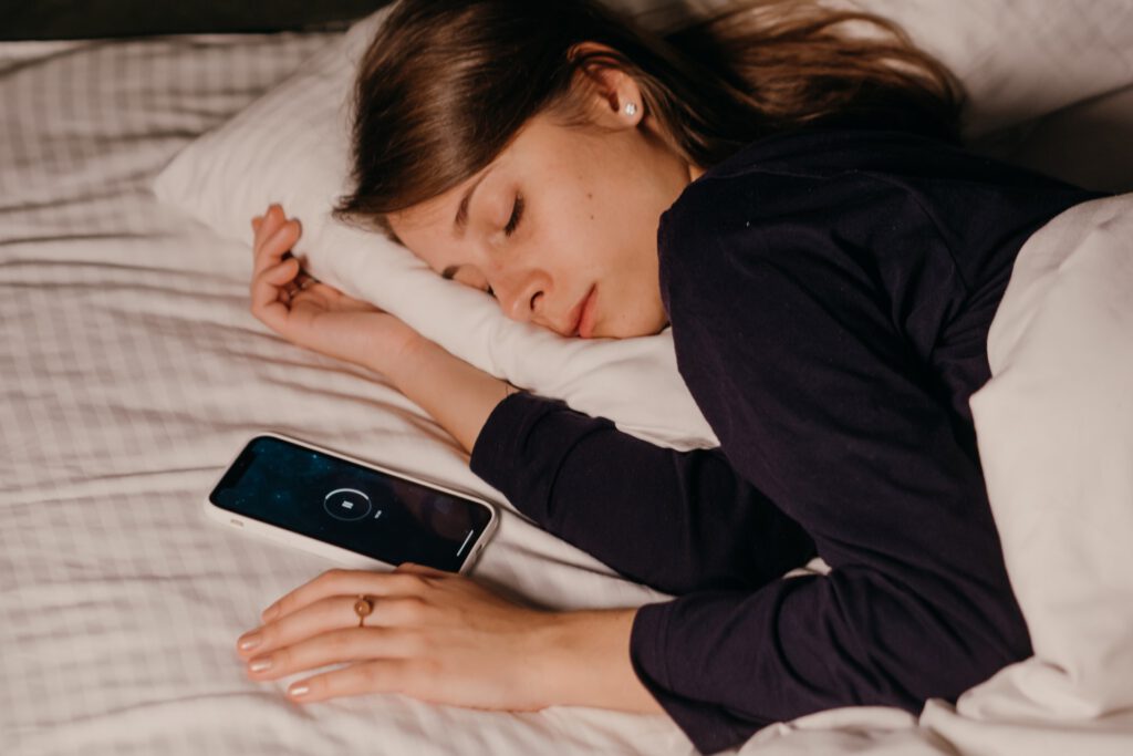 Junge Frau schläft neben ihrem Smartphone Foto: Polina Kovaleva